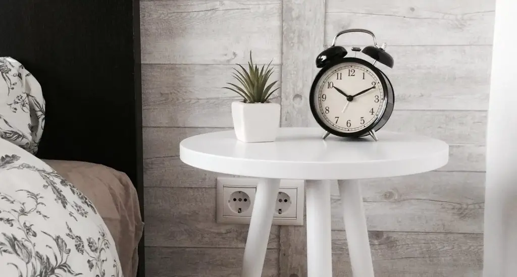 Alarm Clock on the Table Near Bed